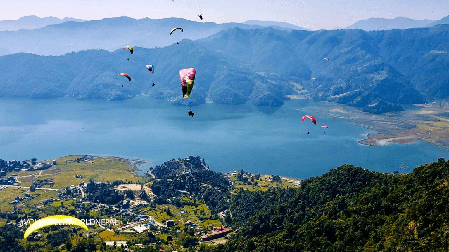 Colorful boats on Phewa Lake with the Annapurna mountain range in the background, Pokhara, Nepal.
